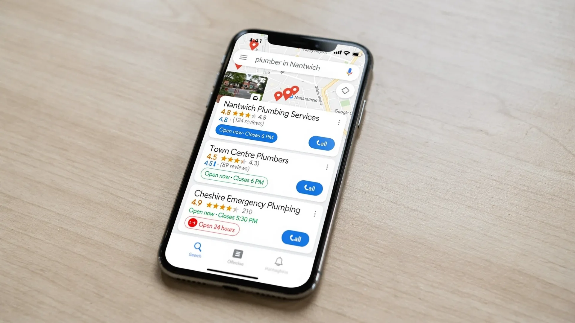 A smartphone showing Google Maps results for a local search like “plumber in Nantwich”, with three Google Business Profiles visible, star ratings, opening hours, and call buttons.