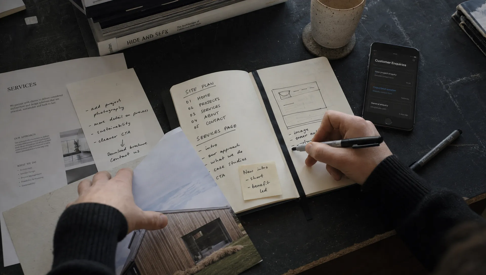Hands sort service-page notes, project photos and customer enquiries while planning a stronger SEO site.