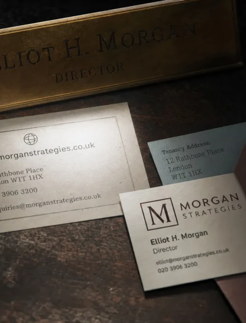 A brass nameplate, contact card and address slip on a dark desk show the facts that help Google recognise one business.