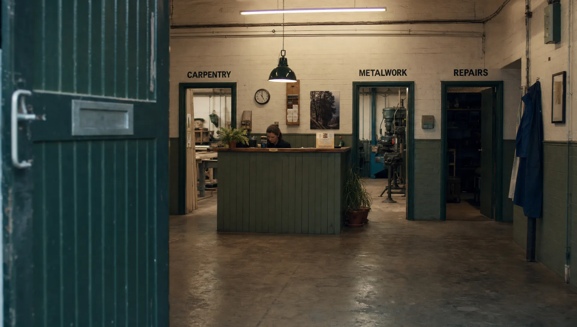 An open front door leads into a working reception area with separate doorways to carpentry, metalwork and repairs.
